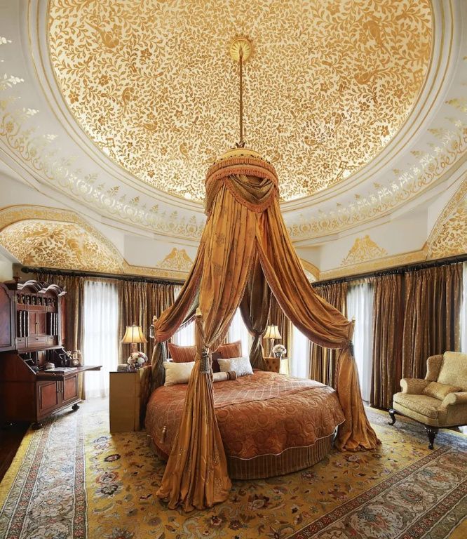 Prächtiges Schlafzimmer mit rundem Bett und kunstvoll gestalteter Decke