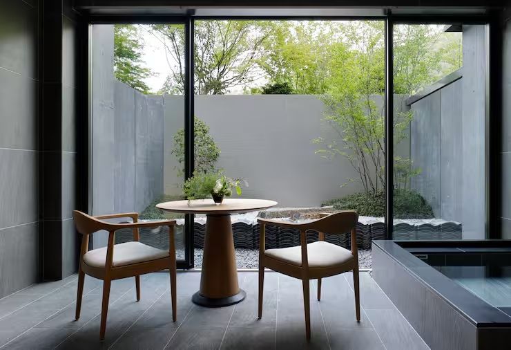 Sitzbereich im Zimmer mit Blick auf den grünen Garten