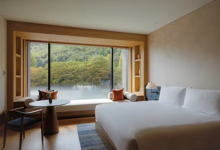 Premier Deluxe Zimmer mit großem Fenster und Blick auf die grüne Landschaft