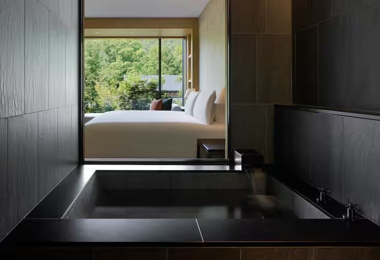 Badezimmer mit Badewanne und Blick auf das moderne Schlafzimmer