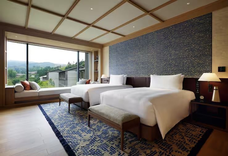 Elegante Doppel Suite mit zwei Einzelbetten und großem Fenster mit Gartenblick.
