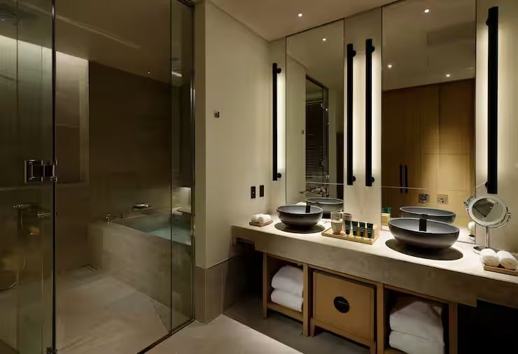 Modernes Badezimmer mit Doppelwaschbecken und beleuchtetem Spiegel in luxuriöser Suite.