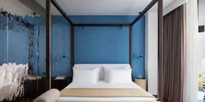 Moderne Junior-Suite mit Himmelbett und blauen Akzenten
