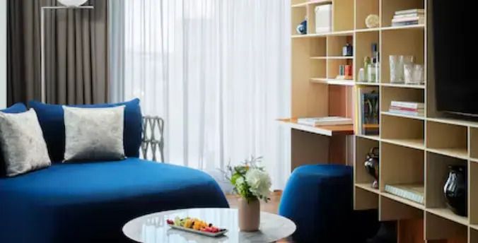 Sitzbereich in Junior-Suite mit blauer Chaiselongue und Schreibtisch