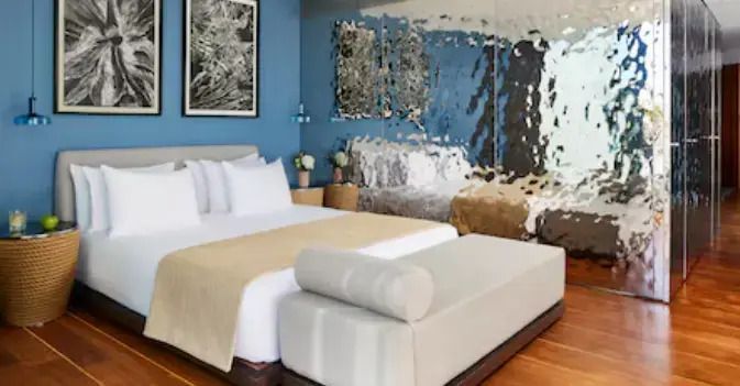 Geräumiges Schlafzimmer mit Doppelbett und moderner Wanddekoration in Blau