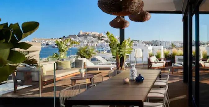 Terrasse mit Blick auf Stadt und Hafen, stilvolle Einrichtung und exotische Pflanzen