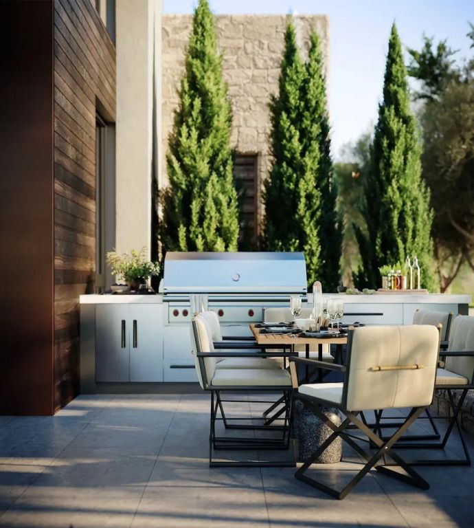 Eleganter Grillbereich im Freien mit Tisch und Stühlen neben Zypressen.