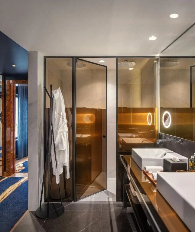 Moderne Suite mit elegantem Bad und Doppelwaschbecken im Forte de Gaia Hotel