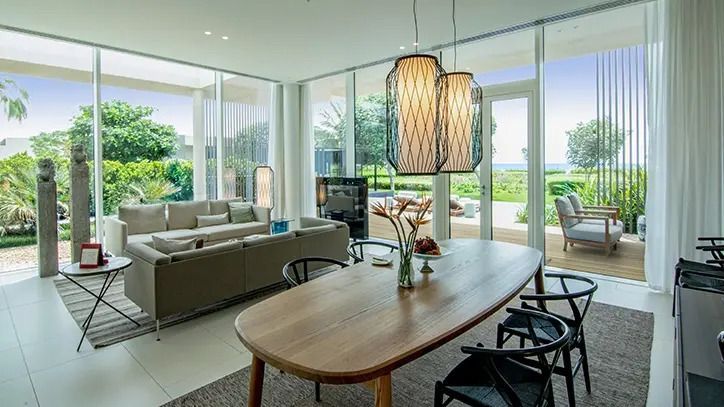 Modernes Wohnzimmer mit großem Holztisch und Blick auf den Garten