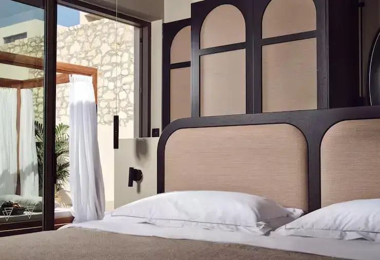 Elegantes Schlafzimmer mit stilvollem Kopfteil und offener Fensterfront