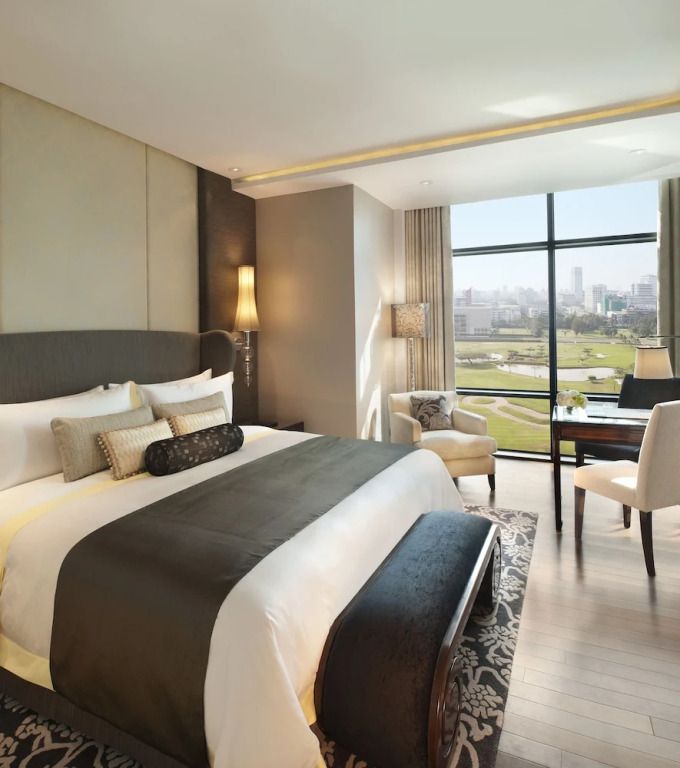Elegantes Doppelzimmer mit großem Fenster und Ausblick auf die Stadt