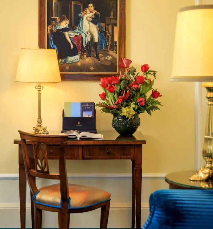Elegante Schreibecke mit Blumenarrangement und klassischem Gemälde