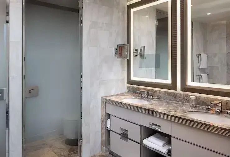 Modernes Badezimmer mit Doppelwaschbecken und beleuchtetem Spiegel.