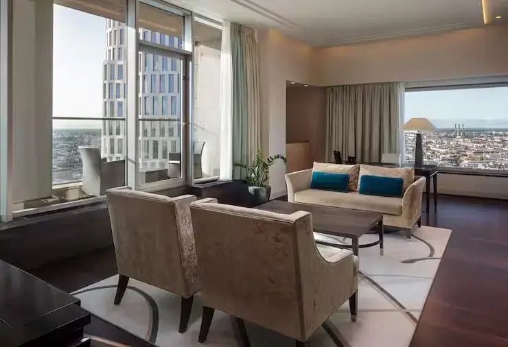 Elegantes Wohnzimmer mit Sitzbereich und großen Fenstern in der Suite