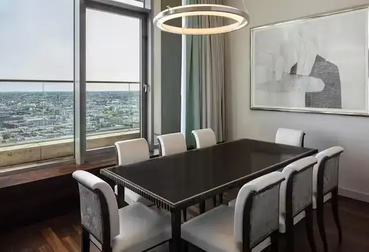 Speisebereich mit großem Tisch und Blick auf die Stadt