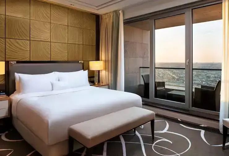 Luxuriöse Suite mit Doppelbett und Balkonblick über die Stadt