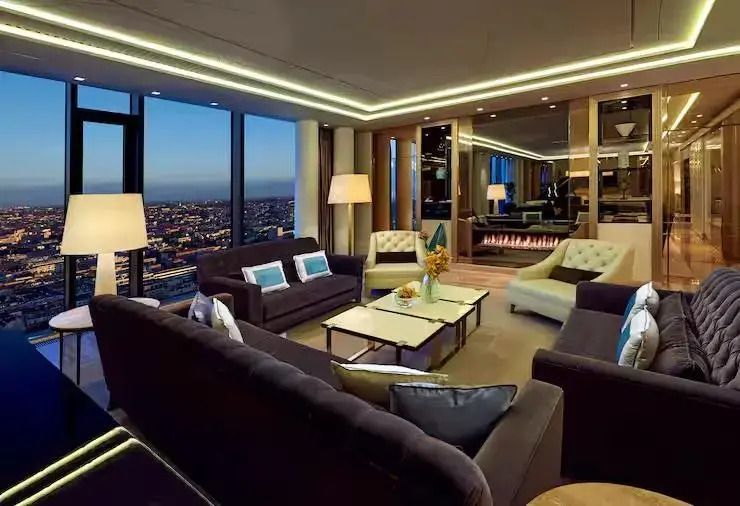 Gemütlicher Aufenthaltsbereich mit Stadtblick und modernem Dekor in der Presidential Suite