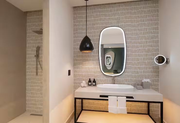 Modernes Badezimmer mit beleuchtetem Spiegel und Regendusche