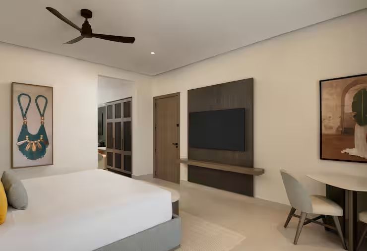 Modernes Hotelzimmer mit Doppelbett und Flachbildfernseher an der Wand
