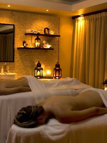Spa-Behandlungsraum mit Massagebänken und beruhigender Beleuchtung