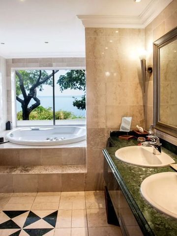 Elegantes Badezimmer mit Doppelwaschbecken und Badewanne mit Blick auf das Meer.