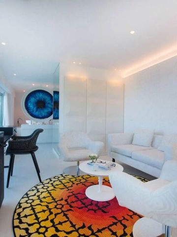 Modernes Hotelzimmer mit hellem Sofa und buntem Teppich