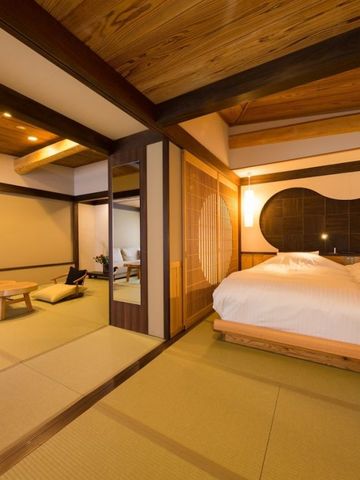 Großes Zimmer mit Tatami-Boden und Doppelbett in warmen Farben