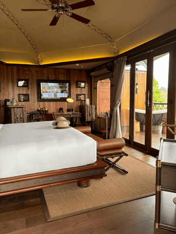 Luxuriöses Hotelzimmer mit Holzinterieur und Blick auf einen Balkon.