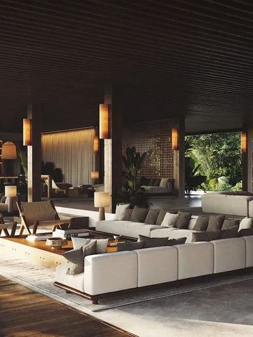 Überdachter offener Bereich mit weichen Sofas und freiem Blick auf die tropische Natur.