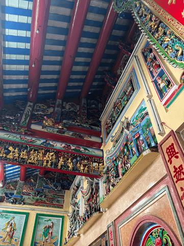 Der Innenraum des chinesischen Tempels beeindruckt mit leuchtenden Farben, kunstvollen Verzierungen und detailreichen Wandmalereien – ein Ort voller Spiritualität und lebendiger Tradition.