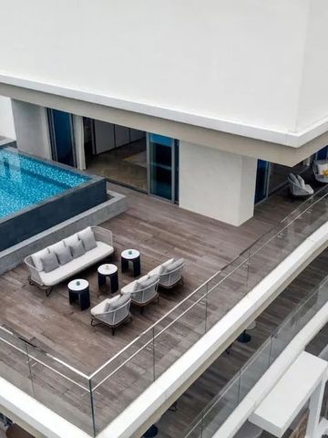 Terrasse auf dem Dach mit kleinem Pool und hellen Sitzmöbeln.
