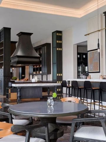 Loungebereich mit Bar, dunklen Holzregalen und modernen Sitzmöbeln.