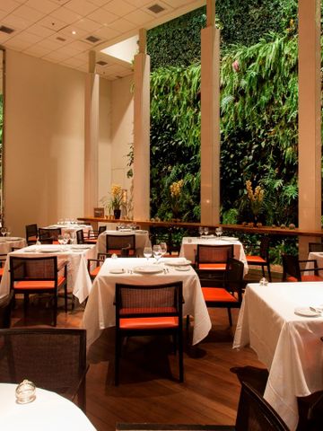 Großzügiger Speiseraum im Restaurant mit gedeckten Tischen und hoher Decke.