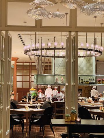 Offene Sicht in eine gehobene Restaurantküche mit Köchen und edler Tischdekoration