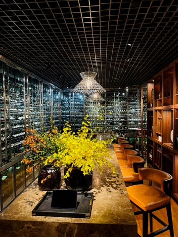 Luxuriöser Weinkeller mit Marmortisch und eleganter Blumendekoration