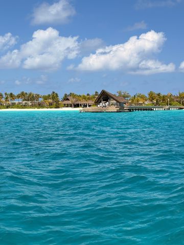 Türkisfarbenes Wasser mit einem hölzernen Pavillon am Horizont unter einem klaren Himmel