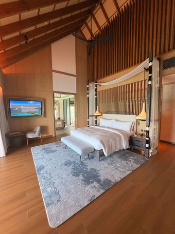 Geräumiges, elegant eingerichtetes Schlafzimmer mit modernem Dekor und Holzakzenten.