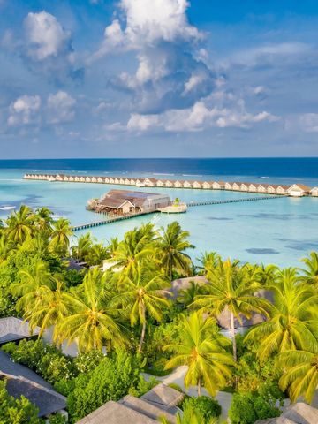 Luftaufnahme eines exklusiven Resorts mit Wasserbungalows im türkisfarbenen Meer