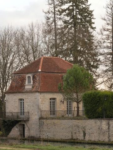 Historischer Steinpavillon mit rotem Ziegeldach und Balkongitter inmitten von Bäumen.