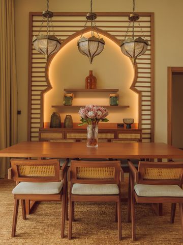 Elegantes Esszimmer mit großer Holztafel und stilvoller Wanddekoration
