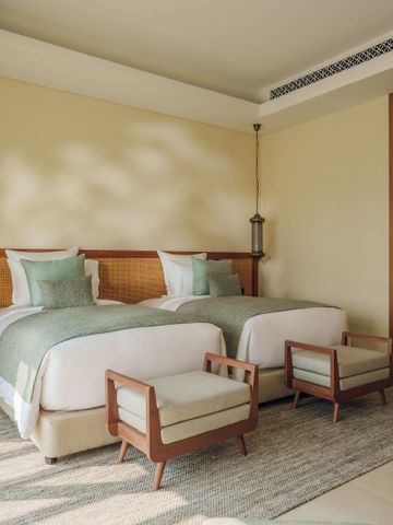 Schlafzimmer mit zwei Betten in neutralen Farben und dezenter Dekoration