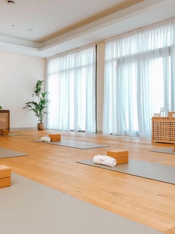 Heller Yogaraum mit Matten und sanfter Dekoration für Entspannung