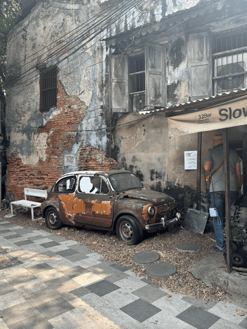 Mitten in den engen Gassen der Stadt stehen alte, verrostete Autos – stille Zeugen vergangener Zeiten, die dem urbanen Flair eine besondere, fast nostalgische Note verleihen.