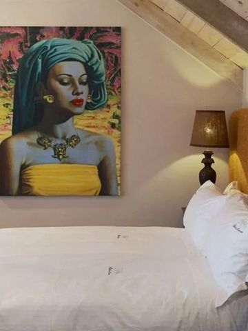 Gemütliches Schlafzimmer mit Kunst an der Wand und sanftem Licht