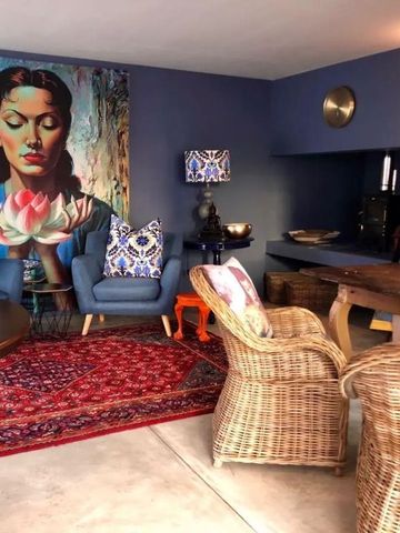 Gemütlicher Lounge-Bereich mit Kunstwerken und bunten Polstermöbeln