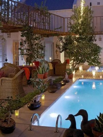 Beleuchteter Innenhof mit kleinem Pool und gemütlichen Sitzmöglichkeiten bei Nacht