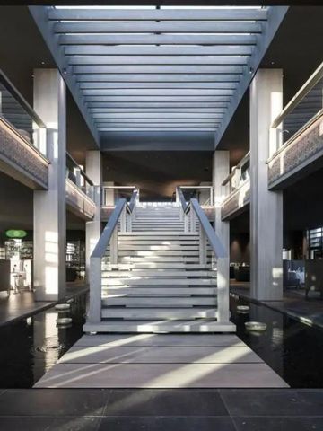 Großzügige Eingangshalle mit einer breiten Treppe und Oberlichtern