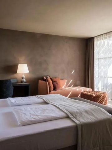 Doppelbett in einem warmen, natürlich beleuchteten Hotelzimmer
