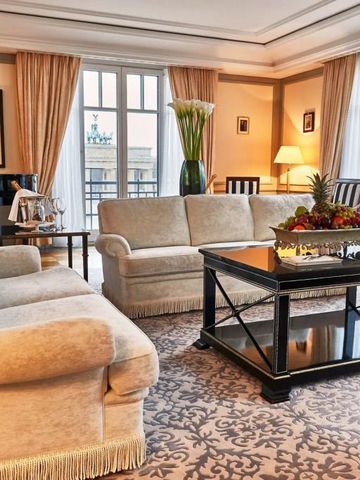 Luxuriöses Wohnzimmer einer Suite mit eleganten Sofas und großem Fensterblick