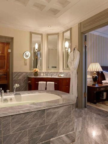 Luxuriöses Badezimmer mit Marmordetails und Blick auf das Schlafzimmer